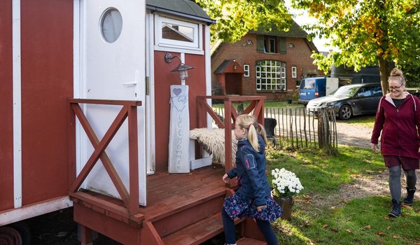 Eine Frau und ein Kind vor einem Tinyhouse