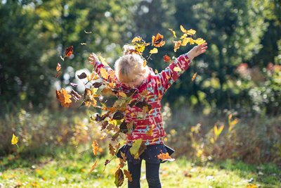 Ein Kind wirft Blätter